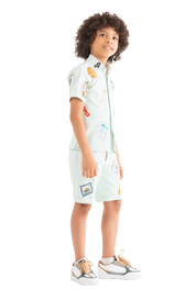 Rhyme Kids - Boy wearing light blue Rhyme by Rupamani twin set with colorful patches and beige sneakers.